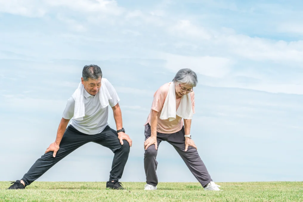外で元気に運動する年配層の夫婦