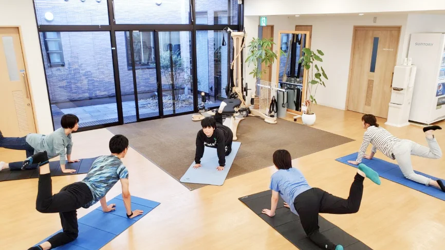 足腰の筋力を効果的に運動する複数の利用者と指導する理学療法士