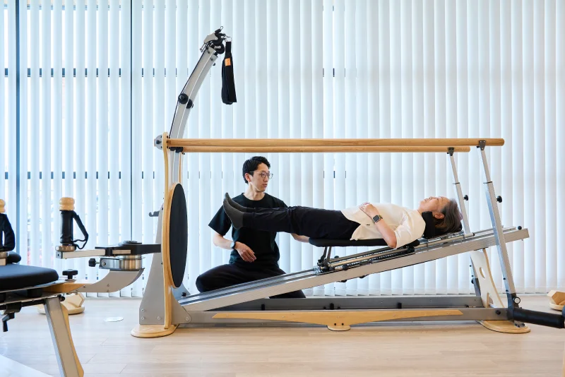 ジャイロトニック®のセッションを受ける女性とサポートする理学療法士