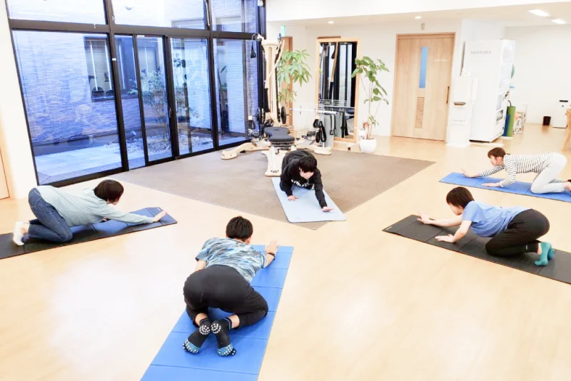 プログラムに沿って、トレーニングをする利用者と指導する理学療法士