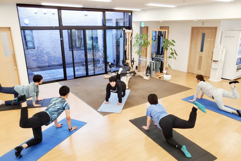 プログラムに沿って、トレーニングする利用者と指導する理学療法士